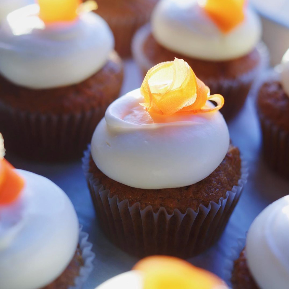 Cupcakes with white icing and a carrot curl on top